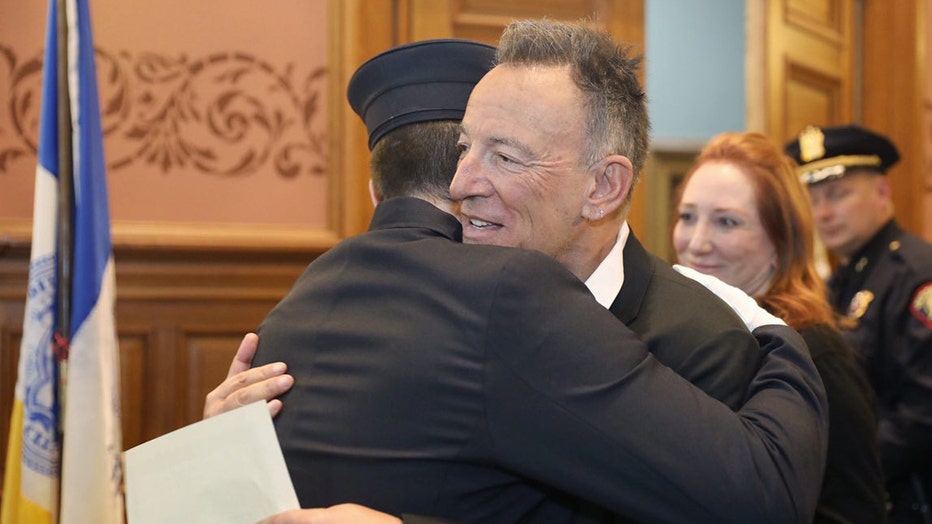 Bruce Springsteen and his son Sam Springsteen embrace at City Hall in Jersey City, N.J., Jan. 14, 2020.