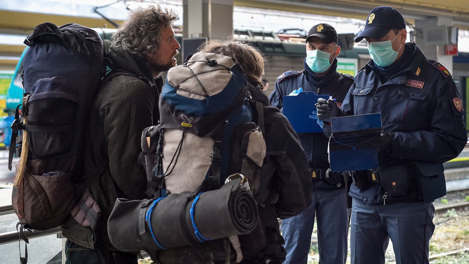 Police officers check passengers leaving from Turin Porta