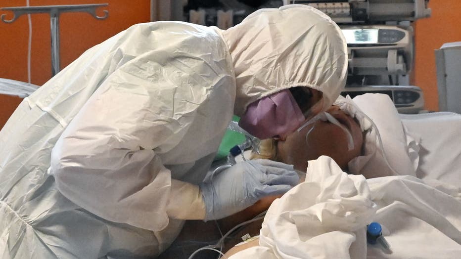 A medical worker in protective gear tends to a patient on March 24, 2020 at the new COVID 3 level intensive care unit for coronavirus COVID-19 cases at the Casal Palocco hospital near Rome. 
