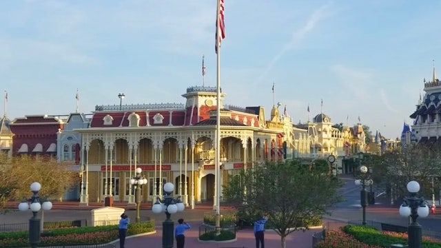 Disney cast members raise American flag inside empty Magic Kingdom