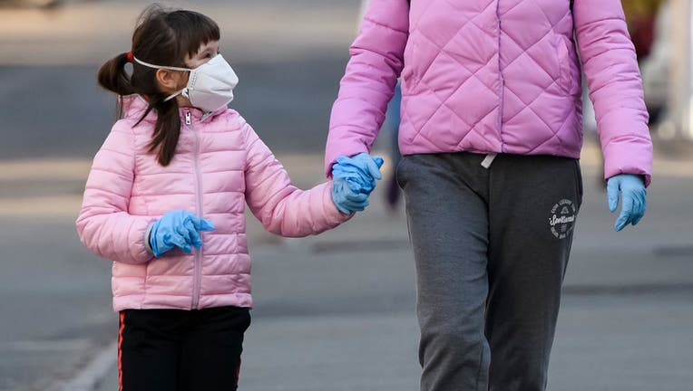 A woman and child are pictured in protective masks on a street in Kyiv, Ukraine on April 4, 2020.