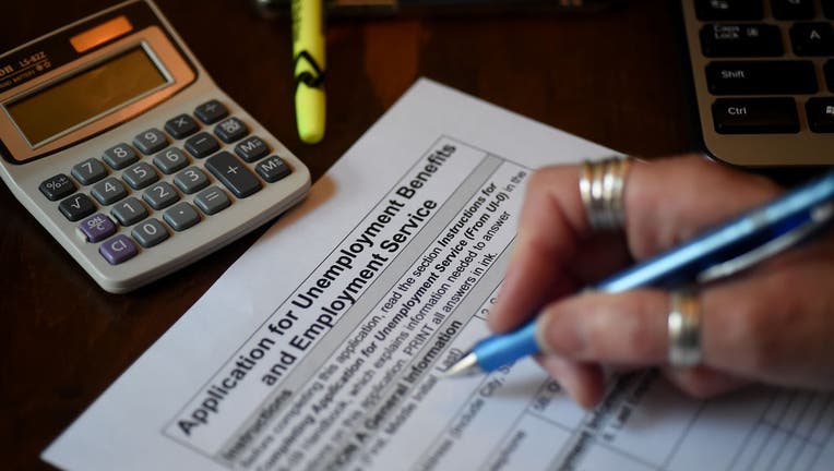 In this photo illustration, a person files an application for unemployment benefits on April 16, 2020, in Arlington, Virginia. 