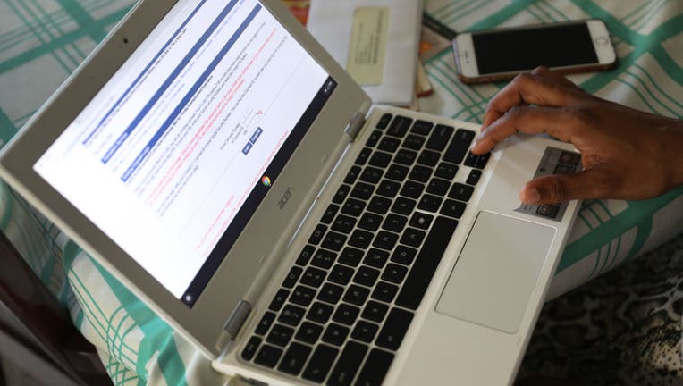 Jessie Morancy uses her computer to fill out an application for unemployment benefits after being laid off from her job at the Fort Lauderdale–Hollywood International Airport on March 27, 2020 in Hollywood, Florida.