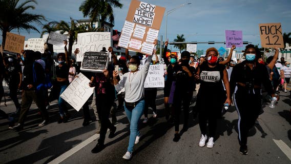 Florida police officer suspended for pushing kneeling woman