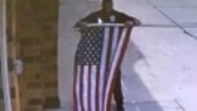 Police officer stops to fix fallen flag outside Nebraska car repair shop