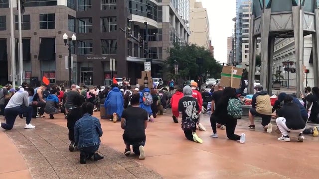 Protesters move through streets of Downtown Orlando, between City Hall and Lake Eola