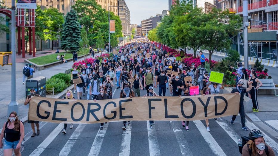 Protesters holding a giant banner reading GEORGE FLOYD at