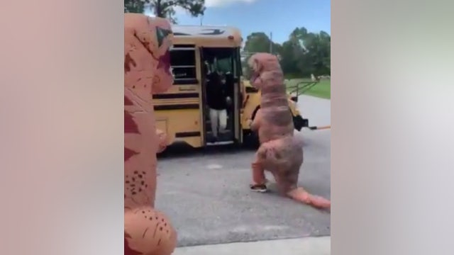Dino-Mite foster parents embarrass Florida teens by meeting them at bus stop in T-Rex costumes