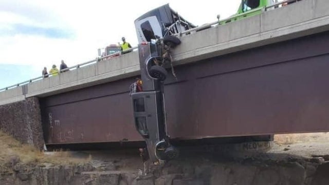 PHOTOS: Rescue team saves couple, 2 dogs from pickup dangling off bridge