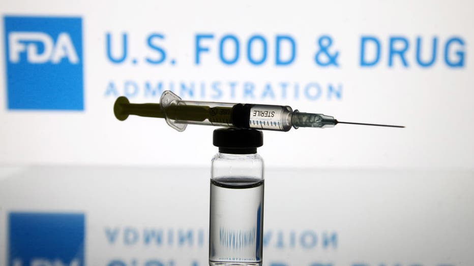 8609cf33-In this photo illustration, a vial and a medical syringe