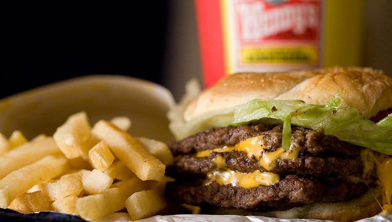 A triple cheeseburger combo is arranged for a photograph in
