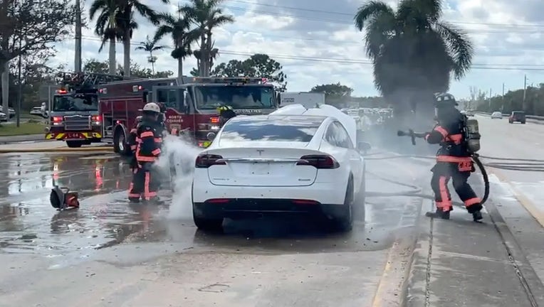 Firefighters in Florida spraying down an EV that caught on fire