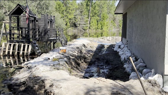Neighbors dig trench to keep St. Johns River floodwaters out of firefighter's home: 'The water keeps rising'