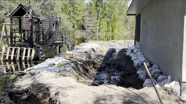 Neighbors dig trench to keep St. Johns River floodwaters out of firefighter's home: 'The water keeps rising'