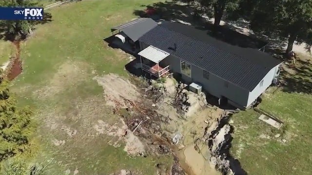 Torrential rain carves massive gully under Mount Dora house, displacing family