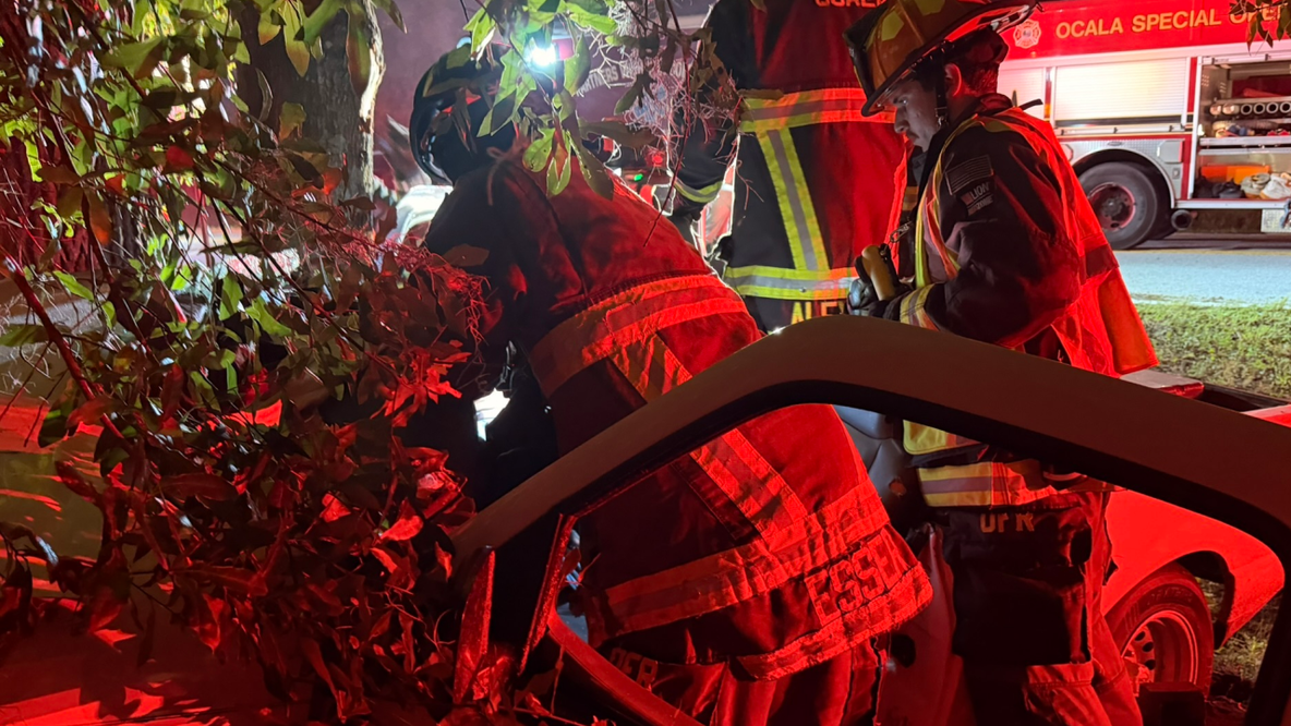 Fire crews free 2 people trapped in pickup truck after crash, wedged between fence, tree