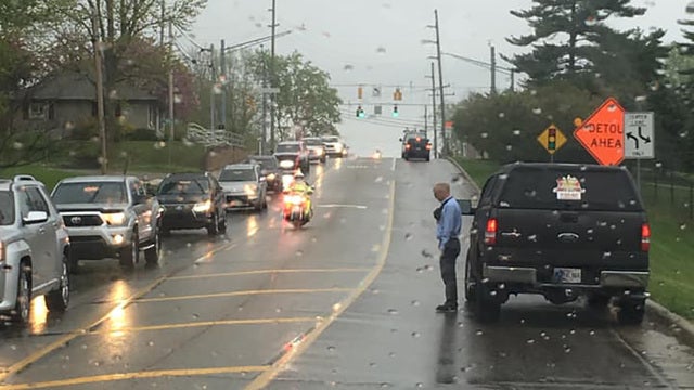 Man gets out of car in pouring rain to pay respects to funeral procession