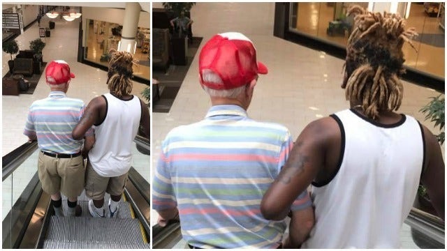 Man helps scared elderly stranger ride down escalator
