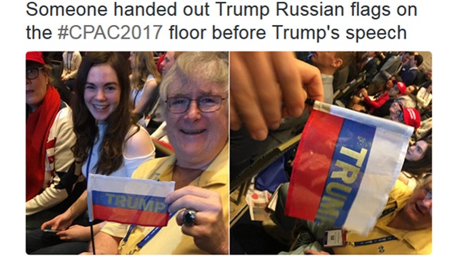 CPAC crowd members briefly wave Russian flags stamped with TRUMP