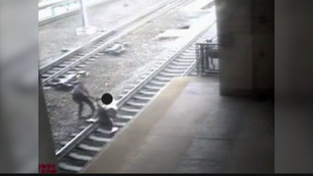 Transit cop saves man lying on train tracks as train approaches