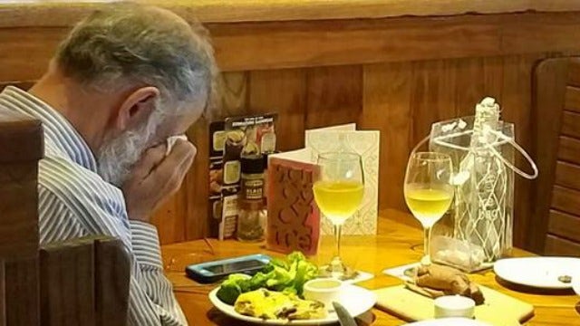 Heartbreaking photo appears to show man eating across from wife's ashes