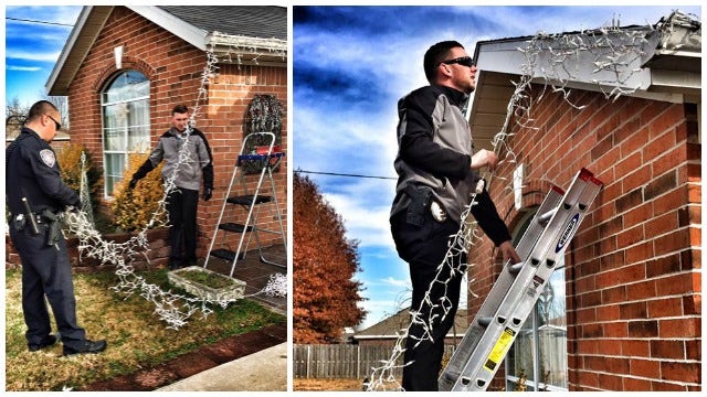 Police officers hang Christmas lights for disabled resident