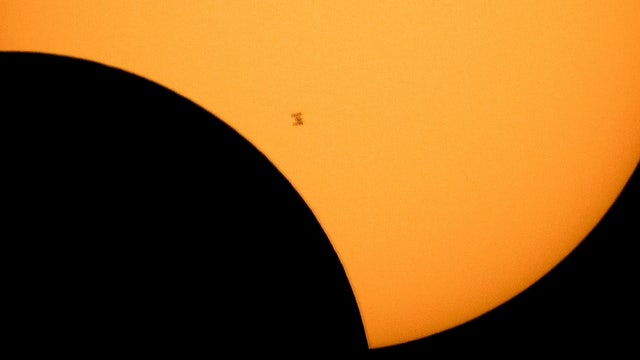 NASA photographer catches space station passing eclipsed sun