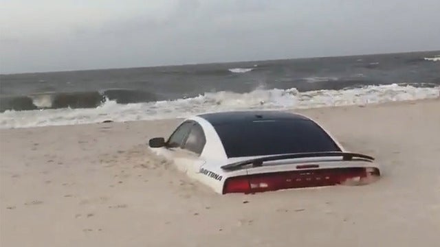 Car buried in sand on Alabama beach as Tropical Storm Barry approached