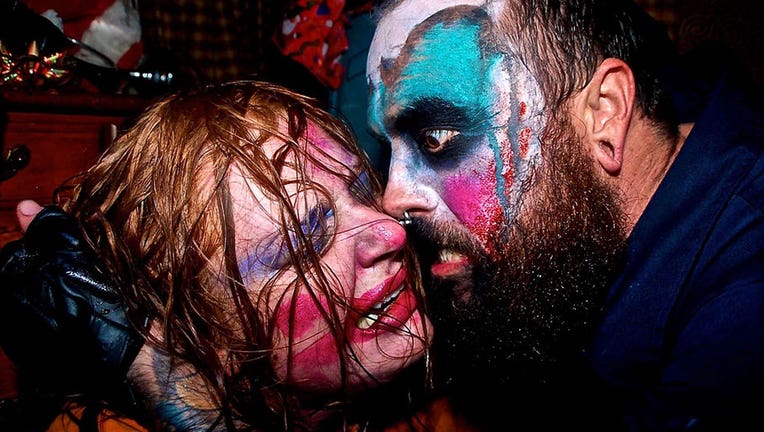 6a0b035a-A scared woman is confronted by a scare actor dressed as deranged clown as part of the McKamey Manor extreme haunted house experience. (Photo credit: McKamey Manor)