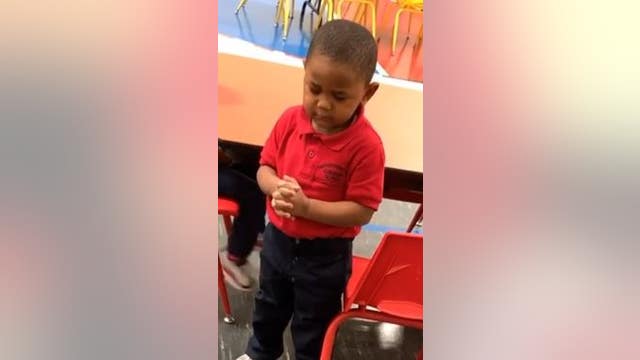 Toddler leads preschool lunch prayer before enjoying a meal with classmates