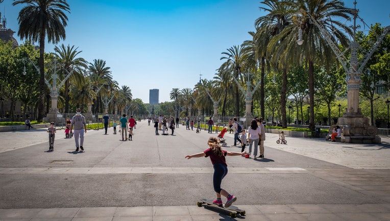 A girl plays with a skateboard during the first day of