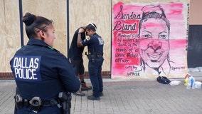 Dallas PD officer shares powerful images of him praying with man who painted murals in Deep Ellum