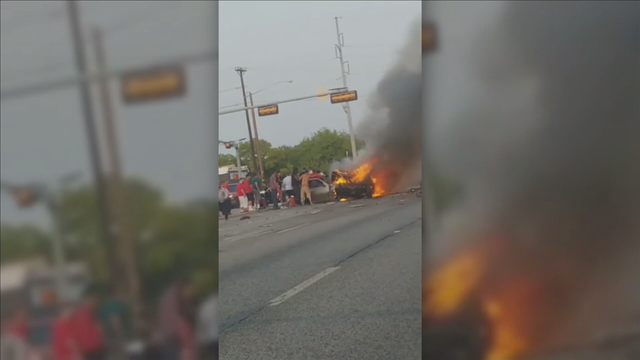 Several people help Dallas PD officers rescue man from burning car