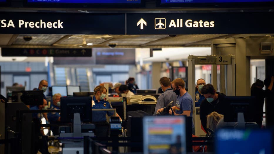 FILE - Travelers make their way through ticketing and TSA inspection as State of Pennsylvania remains under restrictions for work and travel at Pittsburgh International Airport.