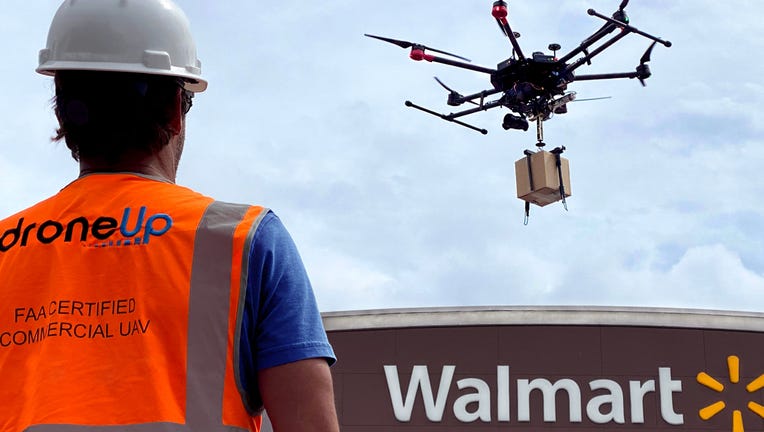 An individual is pictured piloting a DroneUp drone delivery near a Walmart store in a provided image. (Photo credit: Walmart)
