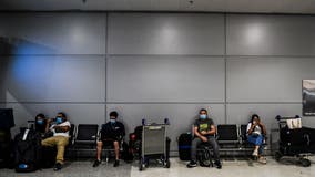 US to keep international travel restrictions for now, citing virus surge