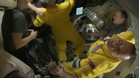 Russian cosmonauts wear yellow and blue flight suits matching Ukrainian flag