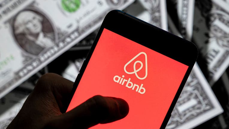 In this photo illustration, an Airbnb logo seen displayed on