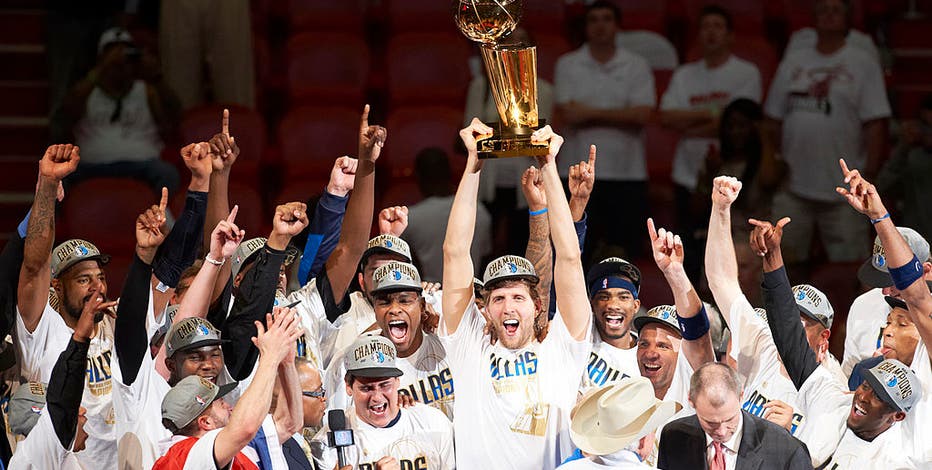 Dirk Nowitzki of the Mavericks holds the championship trophy after  defeating the Heat during Game 6 of the NBA Finals at the AmericanAirlines  Arena in Miami, Florida, Sunday, June 12, 2011. The