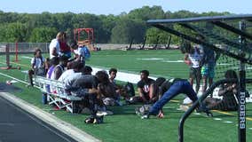 High school football players practice early to beat the heat