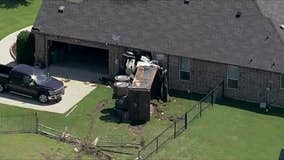 Overturned dump truck hits Haslet home after crash