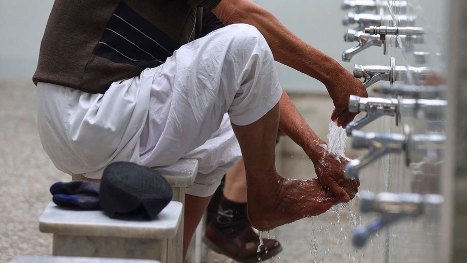 Men perform ablution before praying at the shrine of Sunni Sheikh Abdul Qadir al-Jilani in Baghdad on March 3, 2025, during the Muslim holy month of Ramadan.