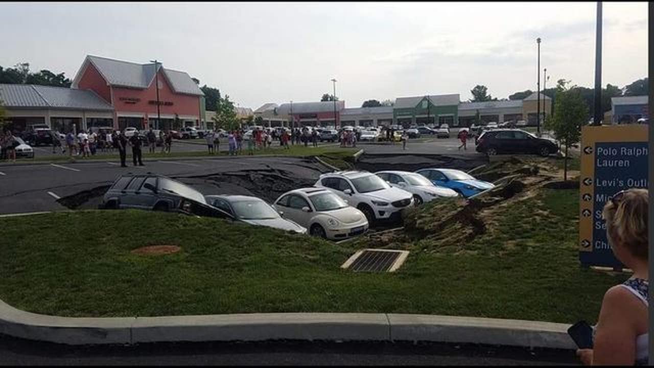 Cars swallowed by sinkhole under outlet mall parking lot