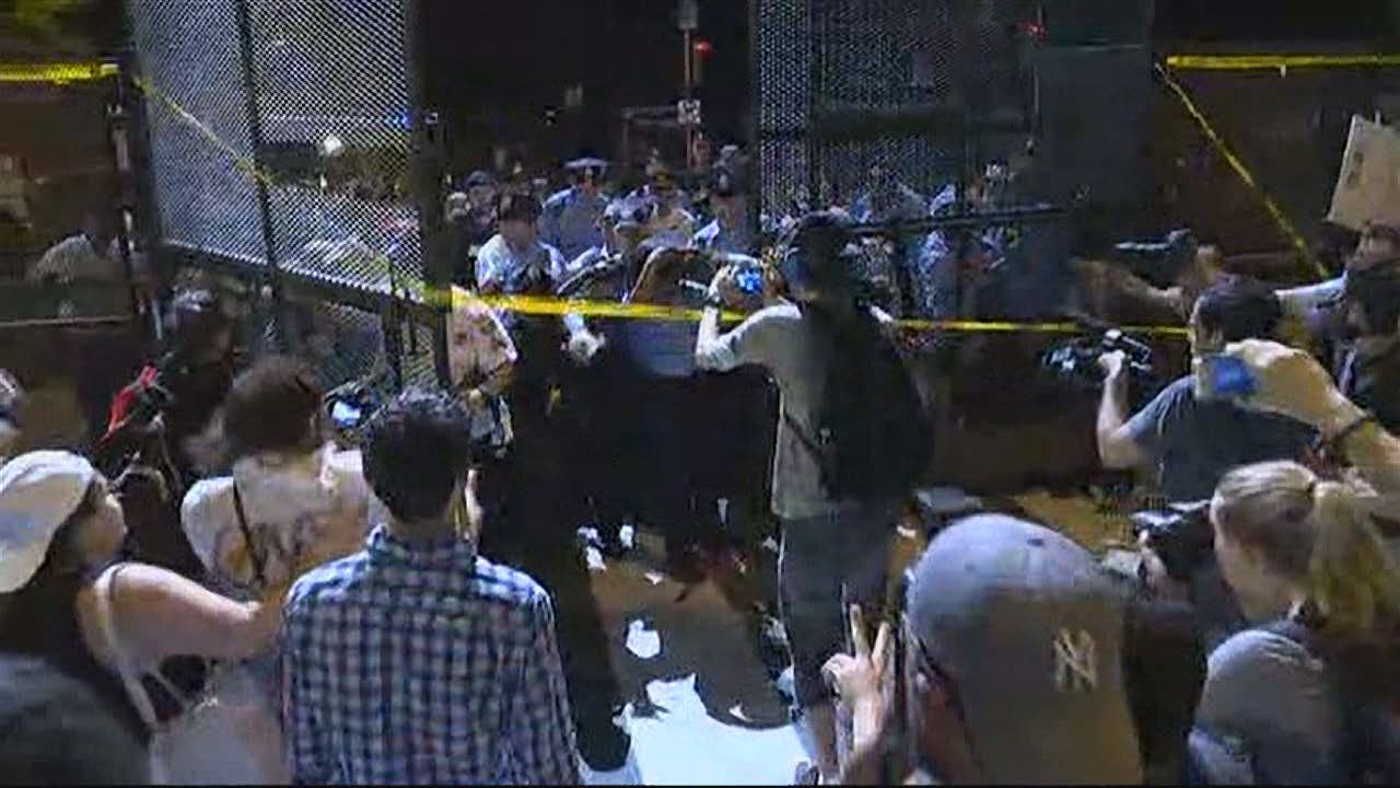 Protesters break through security fencing outside of the DNC