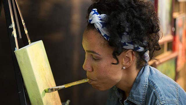 Woman uses her mouth and feet to create one of a kind artwork