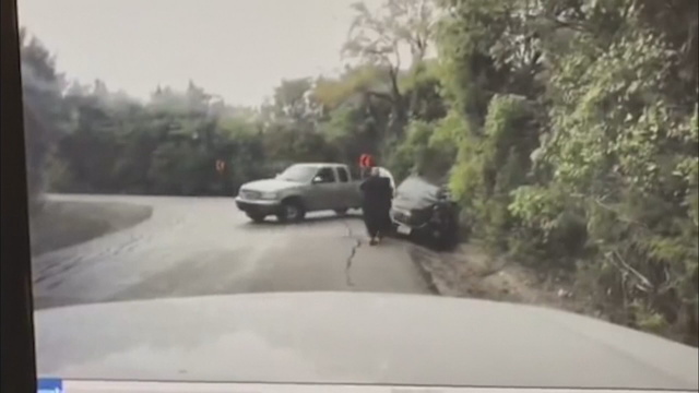 WATCH: Officer pulls woman away from car crash