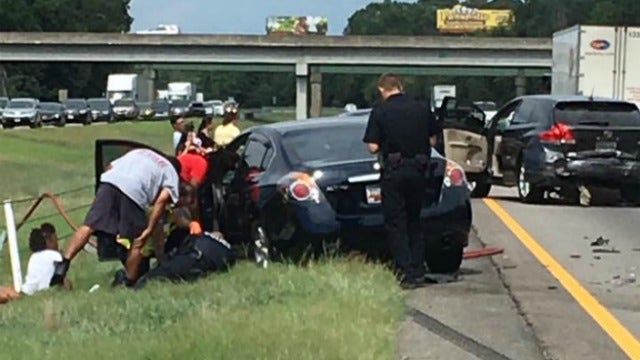 GA police officer seen lying in grass, comforting child after wreck