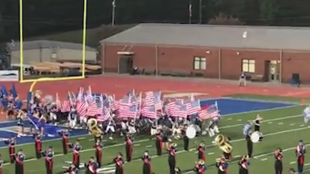 North Georgia high school football team runs onto field with flags