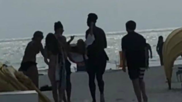 Kindhearted beach-goers carry woman with cerebral palsy