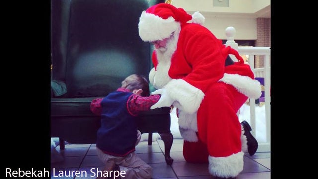 Little boy prays with Santa